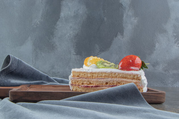 甜点水果和奶油蛋糕片放在小木板上美味糕点奶油