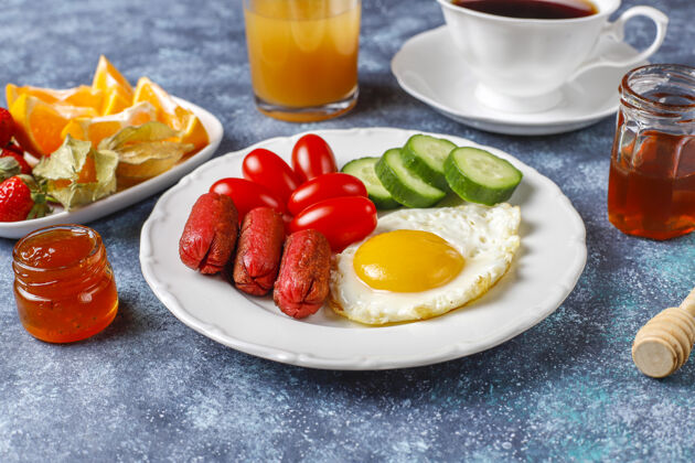 西红柿早餐盘子里有鸡尾酒香肠 煎蛋 樱桃番茄 糖果 水果和一杯桃子汁土耳其食物烧烤