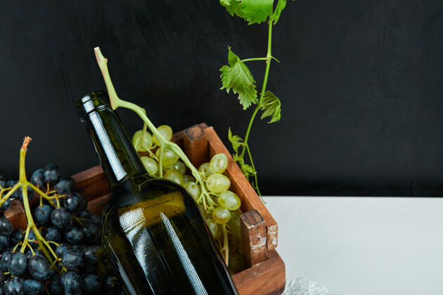 瓶子一堆葡萄和一个白桌子上的酒瓶高品质的照片多汁的美味的盘子