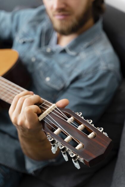 活动特写男人在家弹吉他男人室内音乐