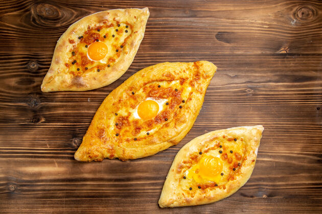 午餐顶视图烤鸡蛋面包从棕色桌子上烤箱新鲜的面团鸡蛋面包包早餐面包早餐膳食