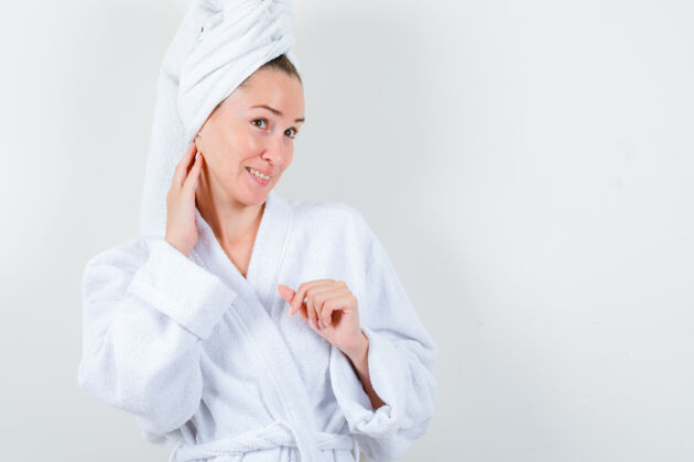 女性穿着白色浴袍 毛巾的年轻女士用手抚摸脖子 仔细观察皮肤正视图水疗健康模特