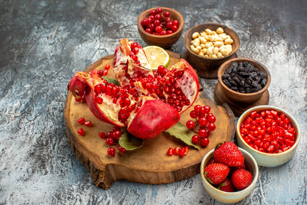 美味前视图切片石榴与其他水果对光暗表树花园水果草莓水果前