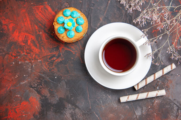 咖啡在黑暗的桌子上俯瞰一杯茶和饼干碗热的茶碟