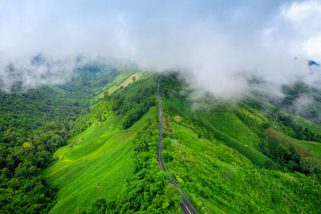 乡村鸟瞰美丽的天路在山顶与绿色丛林在南省 泰国雾目的地乡村