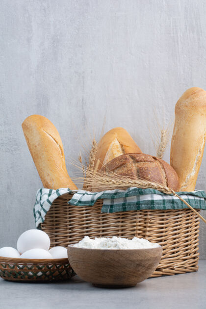 营养面包篮 鸡蛋和面粉在石头表面美味各种面包
