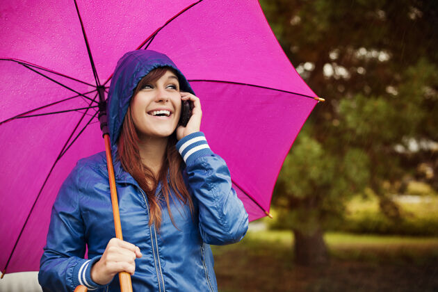 护理雨天带手机的年轻女子无忧无虑天气女性