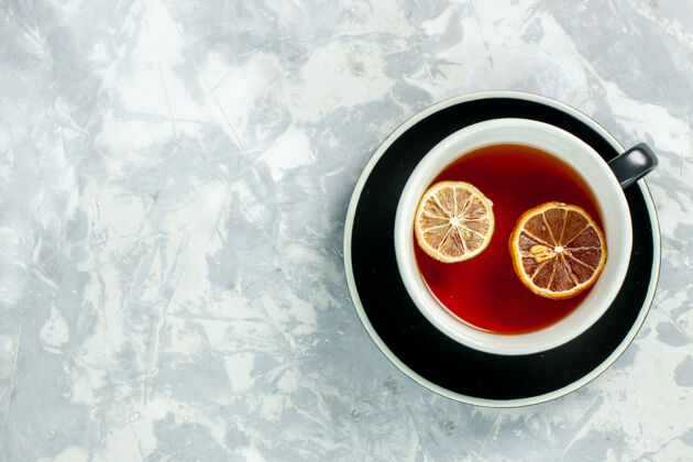 生的顶视图一杯茶 用柠檬片放在白色背景上 茶喝柠檬花圆圈视图柠檬