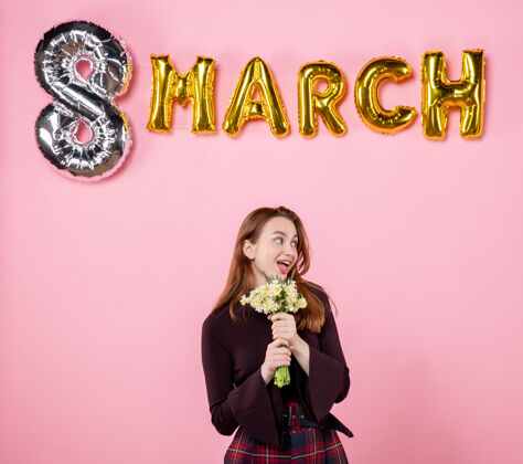 人正面图：手拿鲜花的年轻女性 粉色背景上的三月装饰呈现妇女节三月结婚激情派对平等感性8三月8