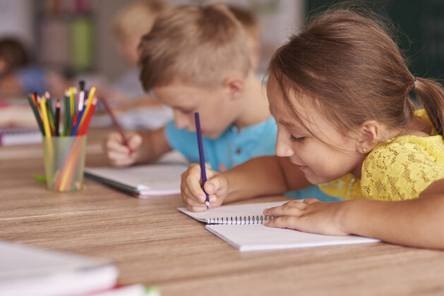 智力小女孩在笔记本上画画女孩技能回到学校