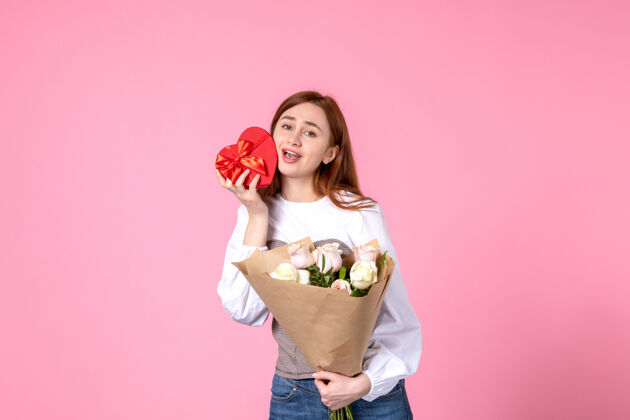 花束正面视图：年轻女性 带鲜花 作为女性节礼物 粉色背景 水平三月平等 女性约会 玫瑰 女性爱情 性感礼物年轻女性玫瑰