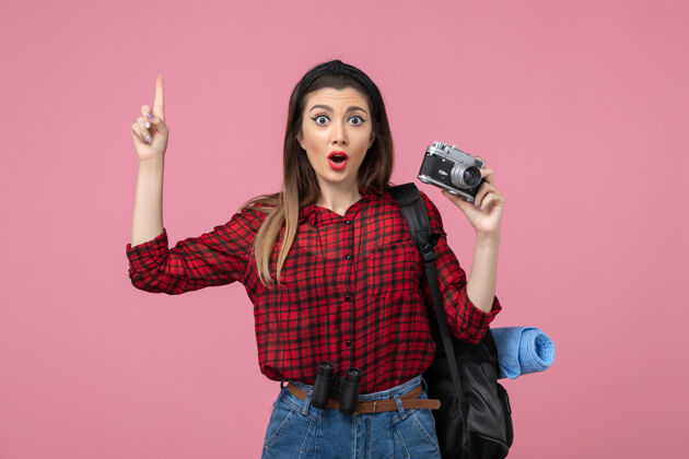 脸前视图穿着红色衬衫的年轻女性 相机放在粉色背景照片上 女模特头发相机成人