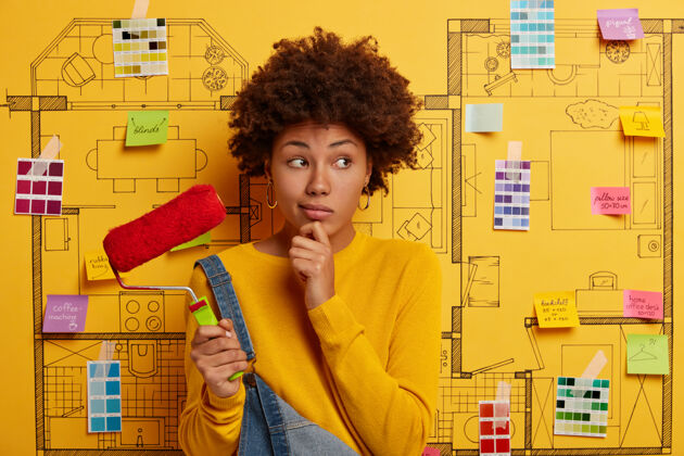 室内年轻女子站在房子旁边设计素描准备装修滚轴彩色调色板