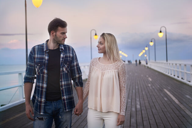 海滩在码头浪漫漫步的情侣异性伴侣深情感性