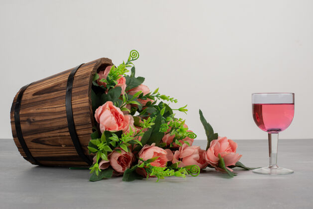绽放美丽的花束和一杯玫瑰红酒摆在灰色的桌子上花束酒玫瑰