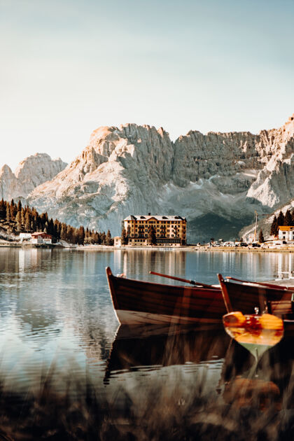 酒店白天在山附近的湖上放棕色的木船山脉湖泊自然