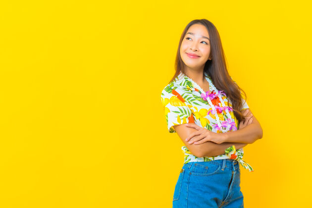 亚洲美丽的亚洲年轻女子穿着彩色衬衫在黄色墙上的肖像文化美丽传统