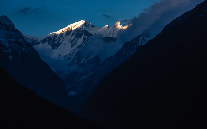 岩石安纳普纳大本营上尼泊尔喜马拉雅山安纳普纳山脉的美丽照片尼泊尔远足阿尔卑斯山
