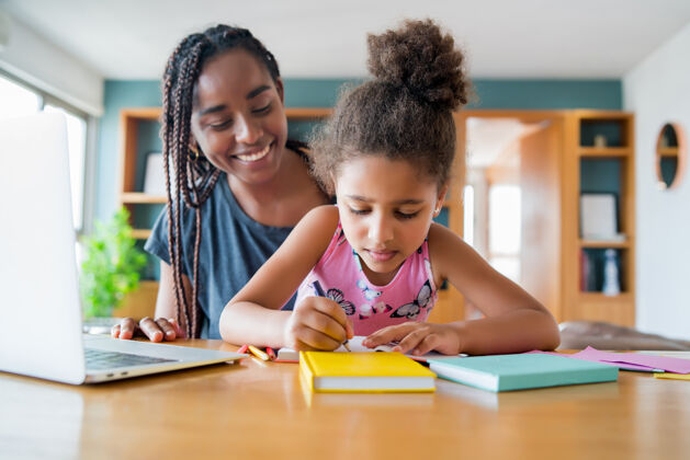 家庭学校母亲在家里帮助和支持女儿上网络学校新的正常生活方式理念单亲观念笔记本电脑家庭作业学习