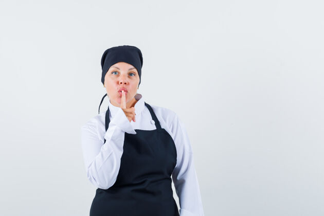女人穿着黑色厨师制服的金发女人 表现出沉默的姿态 看起来很漂亮制服自然头部