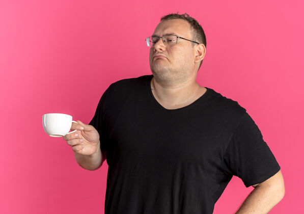 粉色一个戴眼镜的胖男人穿着黑色t恤 手里拿着咖啡杯 看起来很满足 而不是粉色自我满足超重穿着