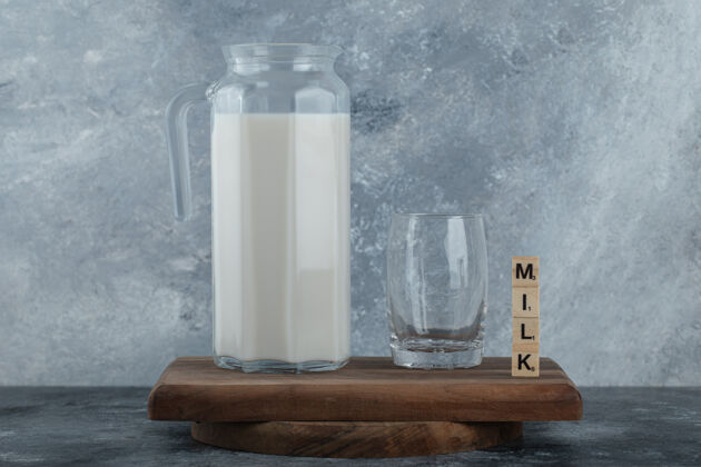 木头在木板上放一壶牛奶和一杯水满的健康产品