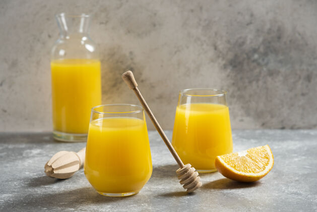 甜味一杯橙汁和一个木勺挤压生的切片
