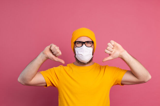 脸戴眼镜的白种人年轻人用一次性医用口罩来预防感染 流感等呼吸道疾病男人表情生病