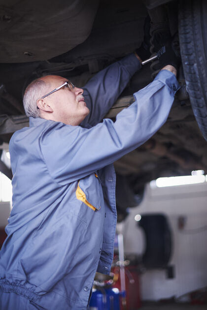 扳手修理工在车间里修理汽车工作工具防护服轮胎