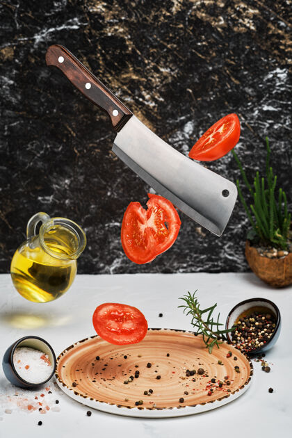 块新鲜成熟的西红柿用刀切好 放在盘子里 放上迷迭香 盐 胡椒和橄榄油叶子健康美味