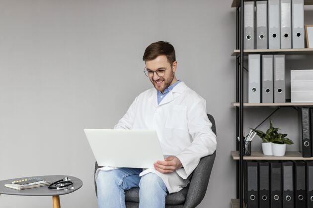 医疗中枪笑脸医生用笔记本电脑医疗专业人士中镜头男人