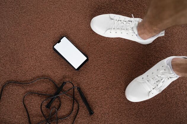 运动员把脚和智能手机放在地上私人教练运动锻炼