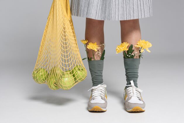 苹果特写的女人拿着乌龟袋 袜子上戴着花女人再利用回收