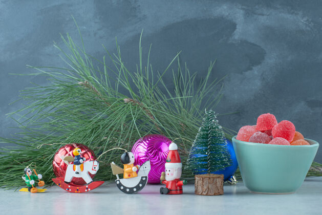 果酱一个蓝色的果酱盘 大理石背景上有圣诞小玩具高质量的照片可食用圣诞玩具甜