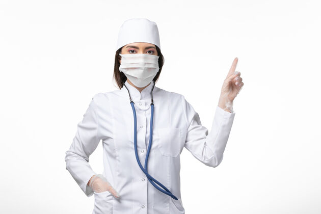 灭菌正面图女医生身穿白色无菌医疗服 带口罩 因白墙上有冠状病毒病大流行病毒冠状病毒视图病毒医疗