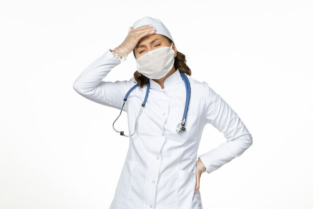 前面白桌上穿着白色医疗服 戴着口罩头痛的女医生潘多米病毒病药医生疾病套装