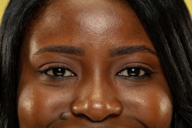 黑发年轻的非洲裔美国女性隔离在黄色的空间里 面部表情美丽女性的眼睛闭上画像魅力漂亮非洲人