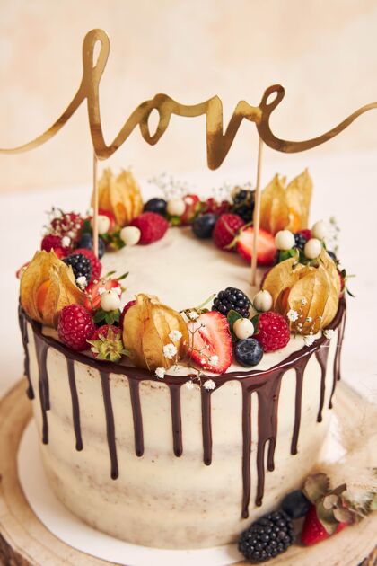 顶部垂直拍摄一个美丽的婚礼蛋糕与水果巧克力滴和爱的顶端美食浆果浪漫