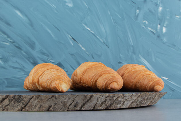 奶油美味的羊角面包在船上 在蓝色的背景高品质的照片面包美味美味