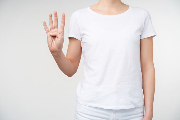 提高摄影棚拍摄的年轻白皙女性举起手 用手指数着四只手 用手语与聋人交谈 被隔离在白色背景下手符号室内