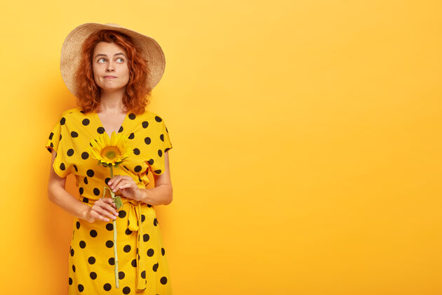 时尚摄影棚拍摄了一位穿着黄色波尔卡裙 头戴草帽的红发美女年轻室内魅力