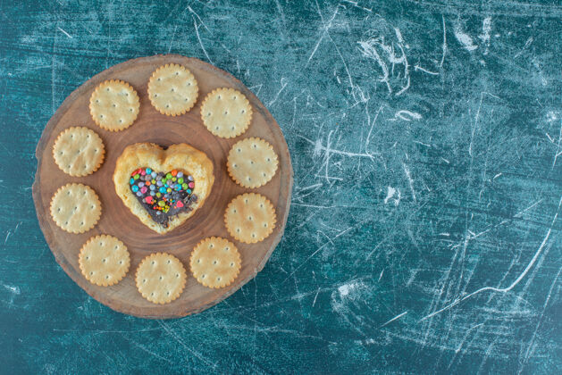 美味饼干围绕在一个蓝色背景板上的心形蛋糕高品质的照片糕点糖果烘焙