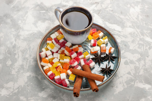 盘子顶视杯茶与果酱和肉桂淡白色表面容器早餐水果