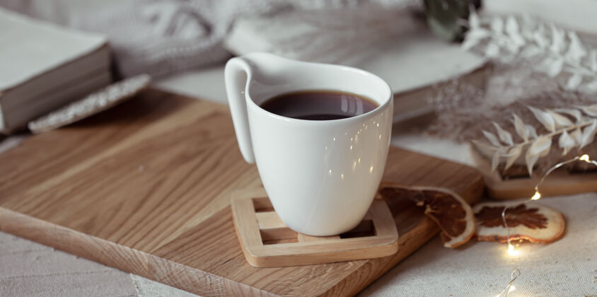 Hygge一杯漂亮的茶或咖啡放在木制的架子上家的舒适概念饮料复制空间舒适