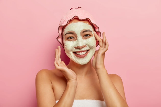 模特SPA面膜应用快乐亚洲女性 用粘土泥改善皮肤状况 在脸上应用化妆品 照顾她的肤色和身体水平人温柔