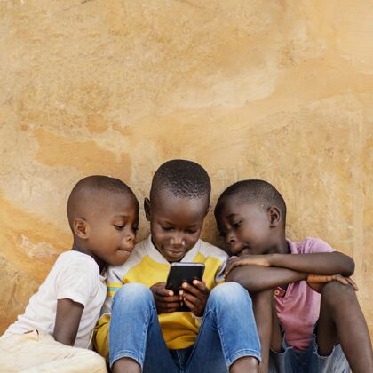 生活方式中等身材的孩子在看智能手机民族中镜头非洲