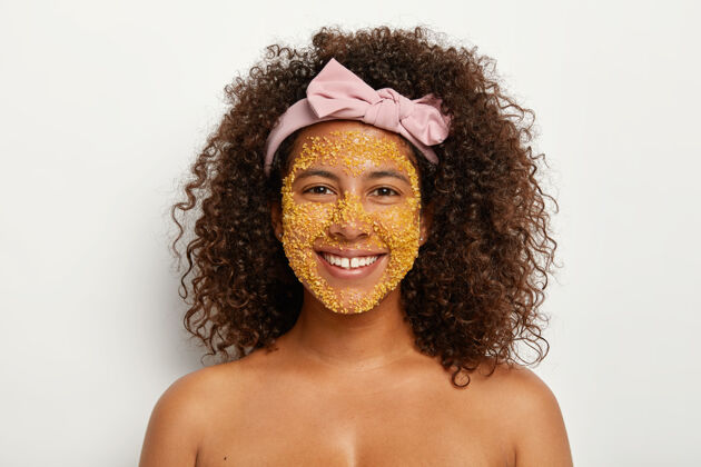 赤膊喜年轻黑皮肤模特使用神奇的皮肤健康成分 脸上有黄盐颗粒 用一切有效的方法来美丽年轻 去除毒素 有卫生程序满意头带涂抹