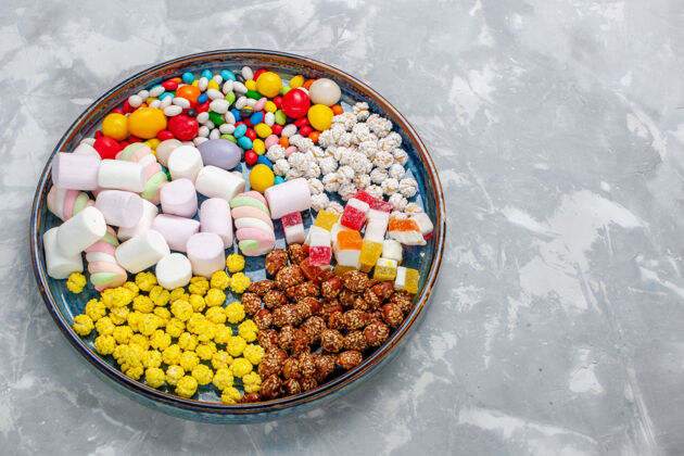 糖顶视图糖果组成不同颜色的糖果与棉花糖在淡白色的办公桌糖糖果邦邦甜壁橱生的水果颜色