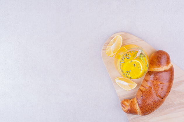 香草羊角面包和一杯柠檬水在白色的表面零食饮料糕点