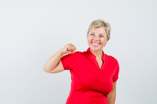 女性穿着红色t恤展示成功姿态的成熟女性 看起来很快乐红色喜悦肖像